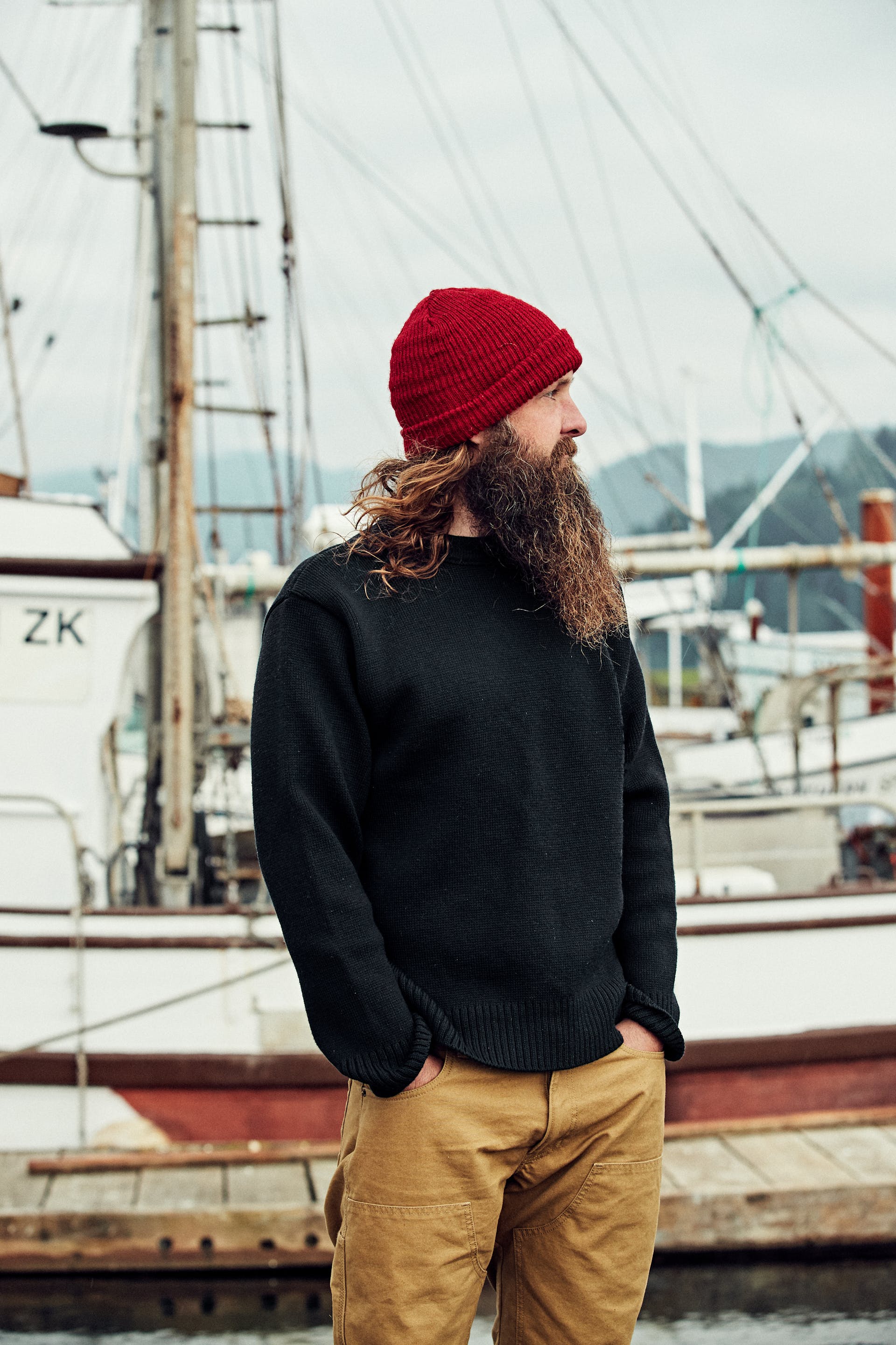 Sailor standing on a dock wearing a Filson Crewneck Guide Sweater