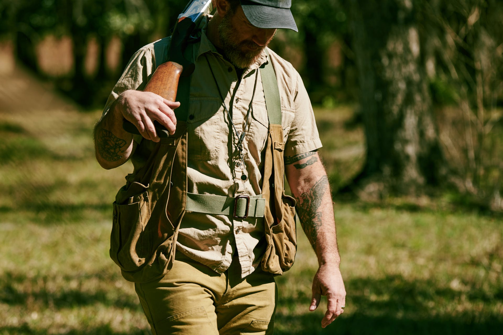 Man walking through a field with a gun wearing a Filson Washed Short Sleeve Feather Cloth Shirt
