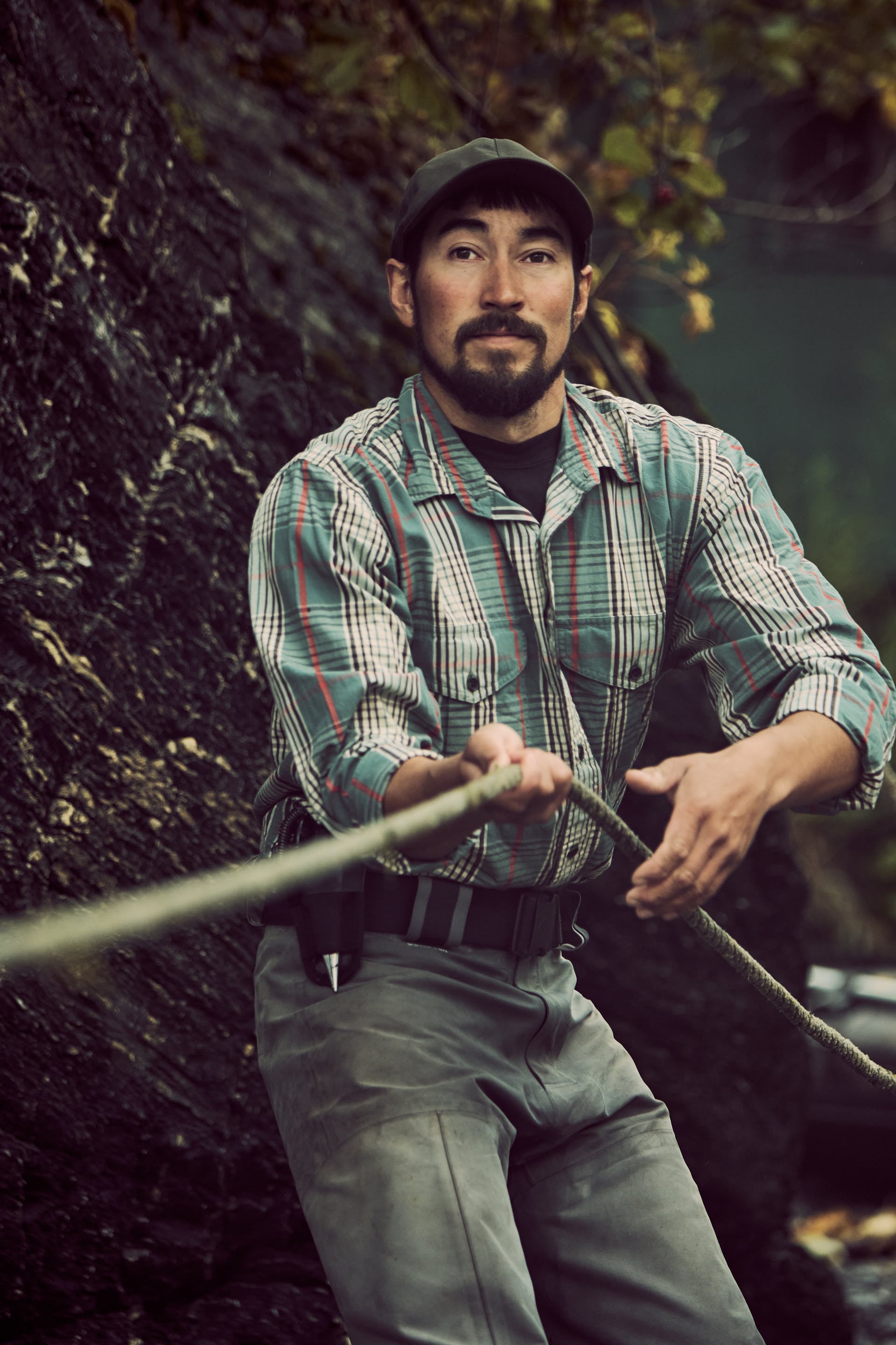 Man pulling on length of rope wearing a Filson Washed Feather Cloth Shirt