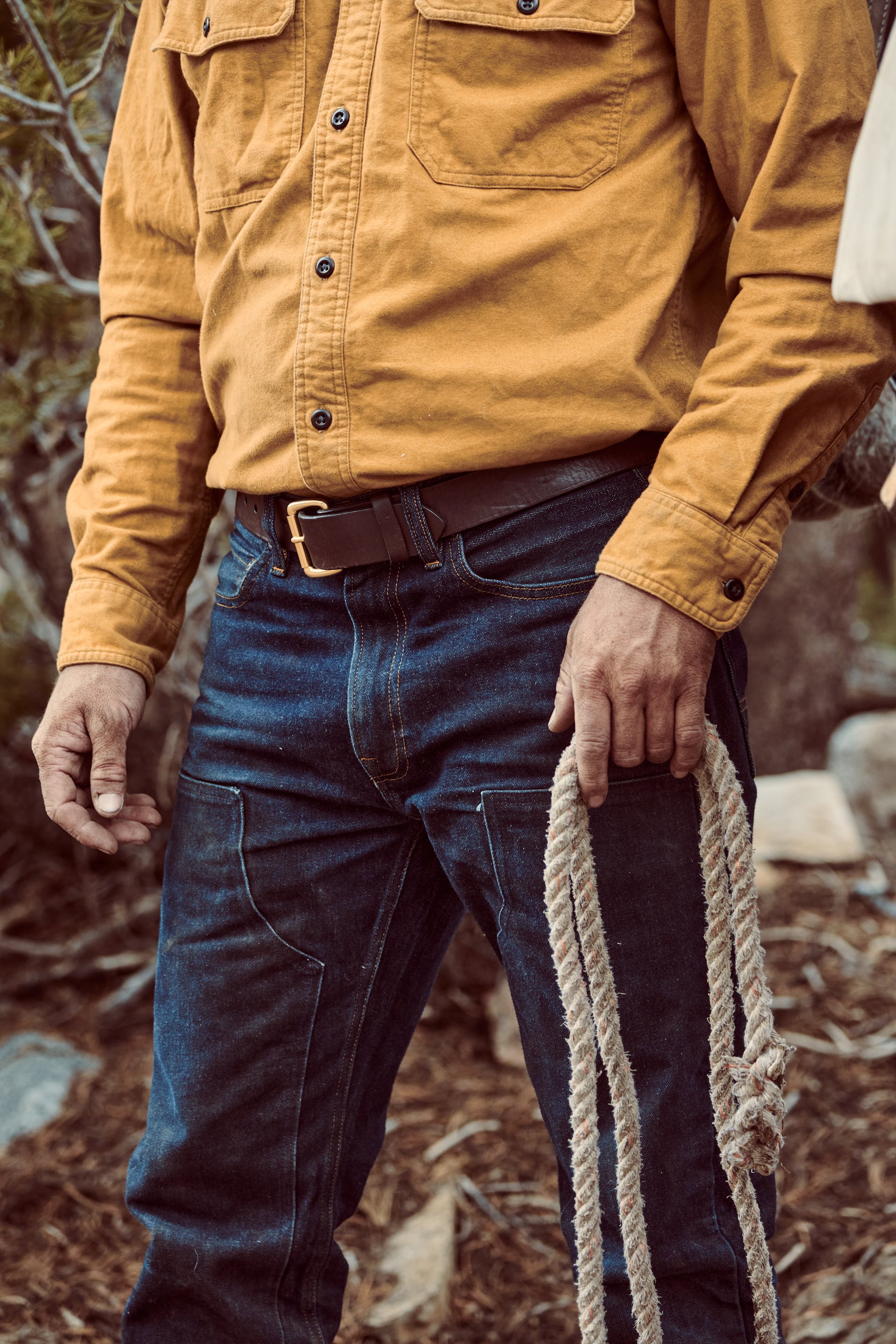 Man holding a cotton rope wearing Filson Bullbuck Double Front Jeans in rinse indigo