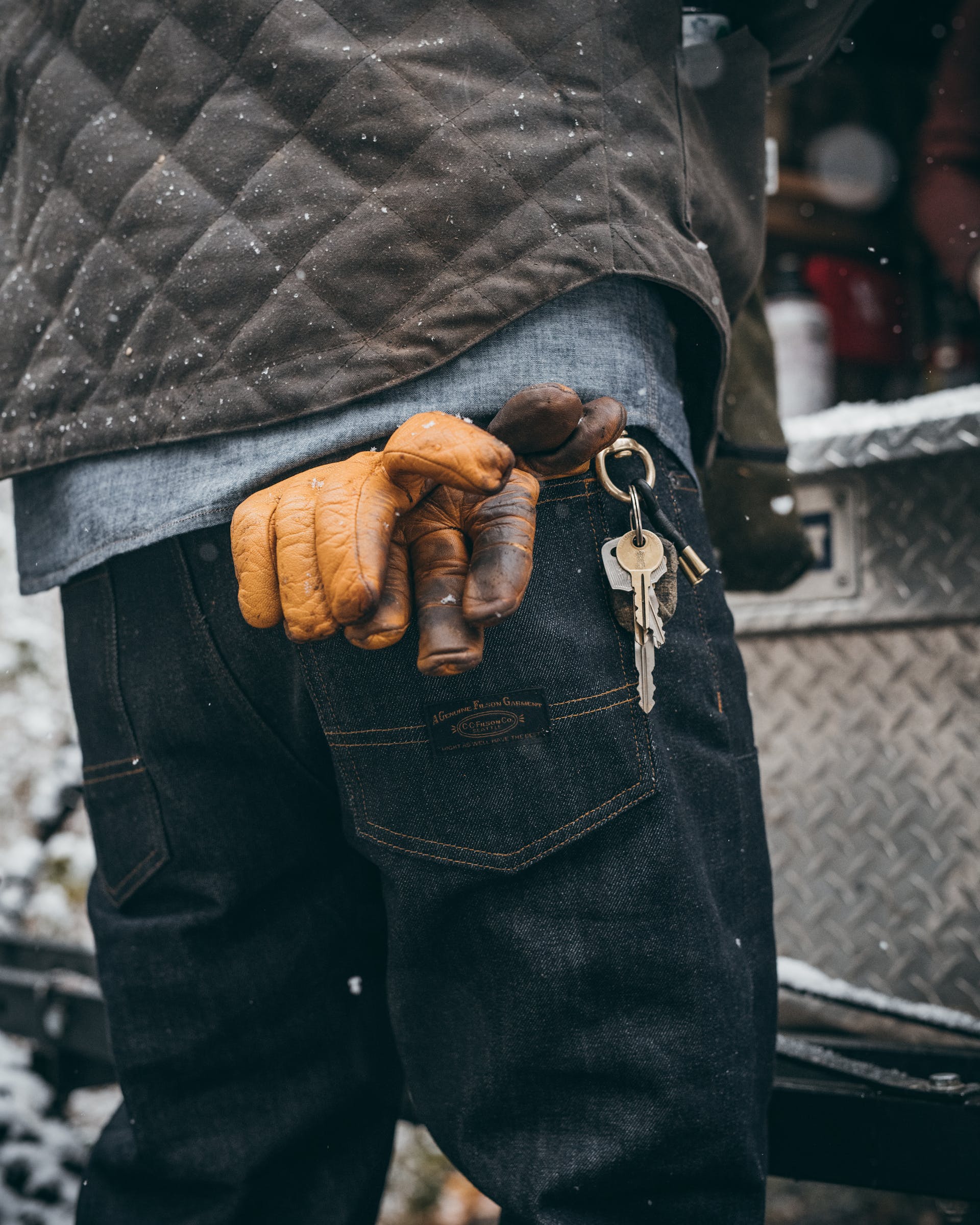 Back view of Filson Bullbuck Double-Front Jeans in raw indigo with gloves tucked into back pocket